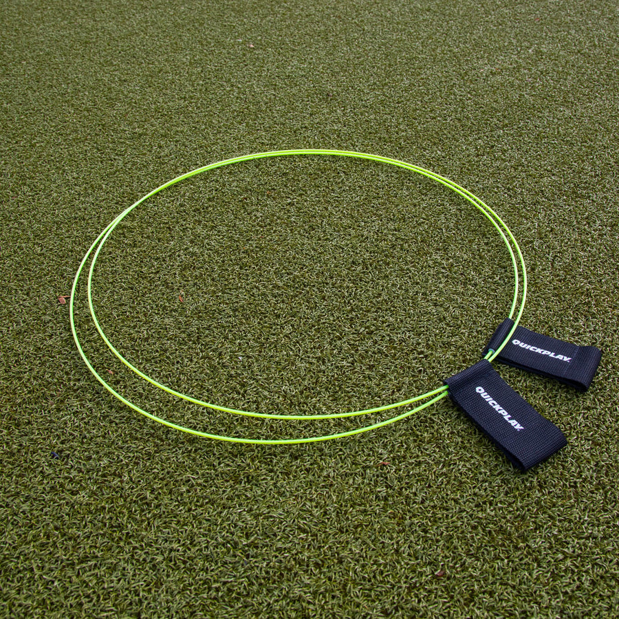 Anelli bersaglio KICKSTER (set di 2) distesi su erba sintetica, due anelli gialli con cinghie nere QUICKPLAY.