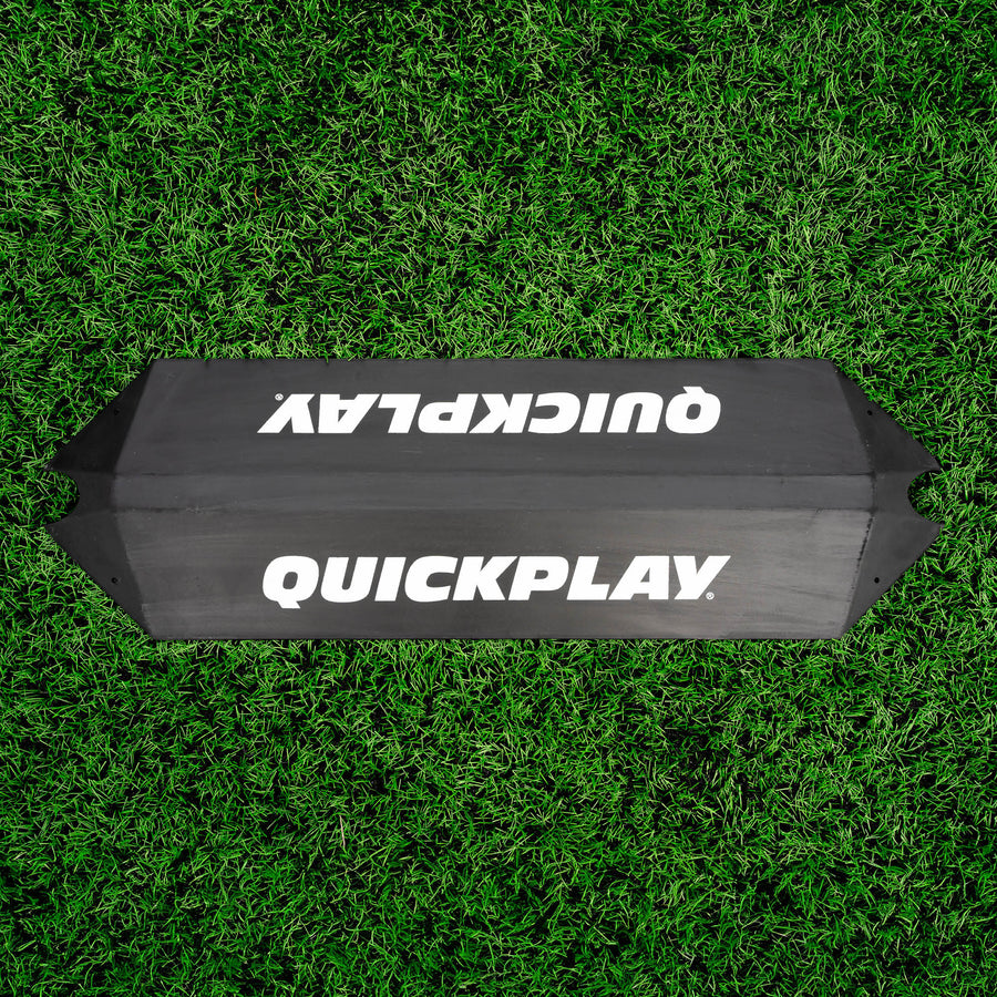 Deviatore a rampa per l'allenamento dei portieri visto dall'alto su erba sintetica, con un logo QUICKPLAY su ogni faccia inclinata.