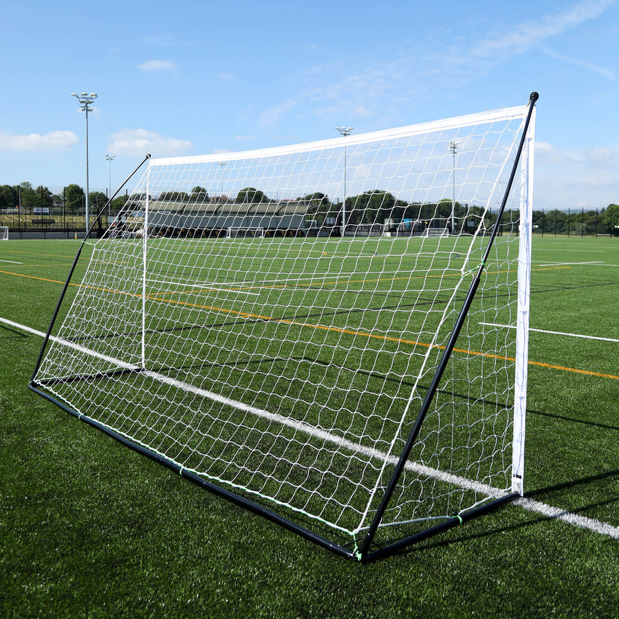 Porta KICKSTER Elite 370 x 180 cm vista da dietro in diagonale su un campo in erba sintetica, con il telaio posteriore nero.
