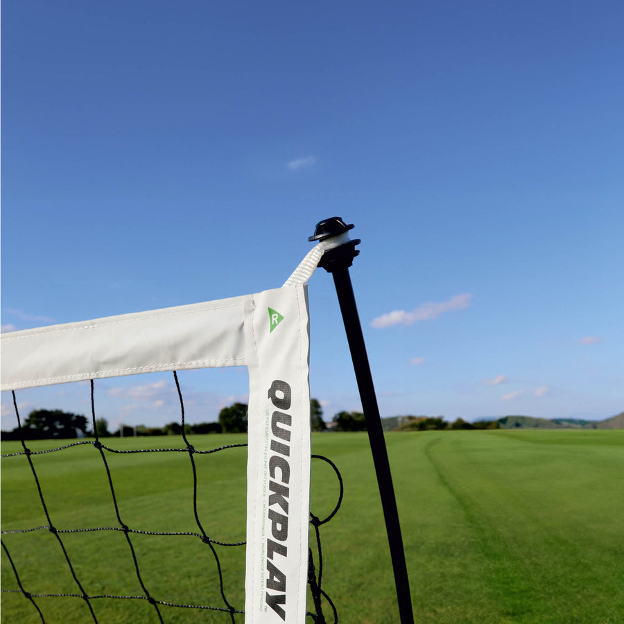 Primo piano dell'angolo superiore della porta da calcio a 5 KICKSTER Elite 300 x 200 cm, con il manicotto bianco QUICKPLAY, la rete e l'asta di supporto nera.