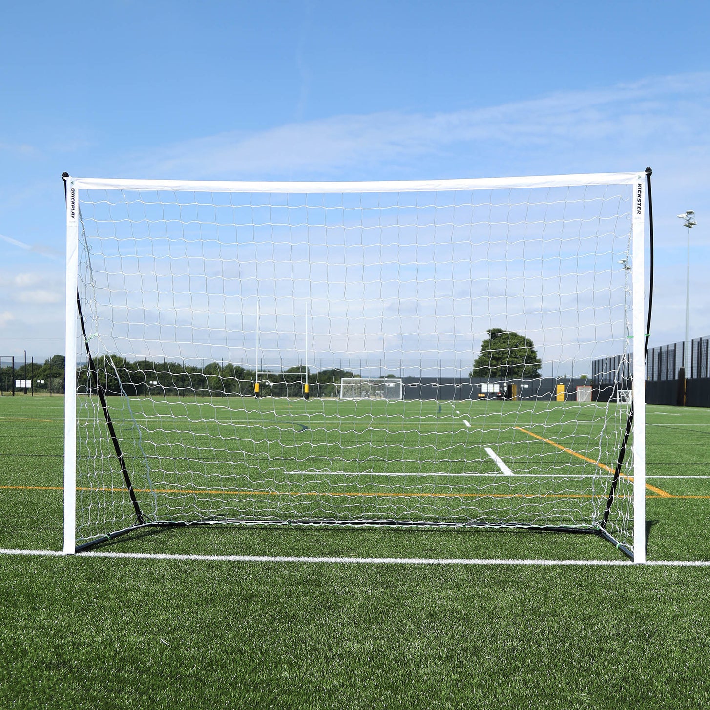Porta da calcio a 5 KICKSTER Elite 300 x 200 cm vista frontalmente, con telaio e rete bianchi su un campo in erba sintetica.