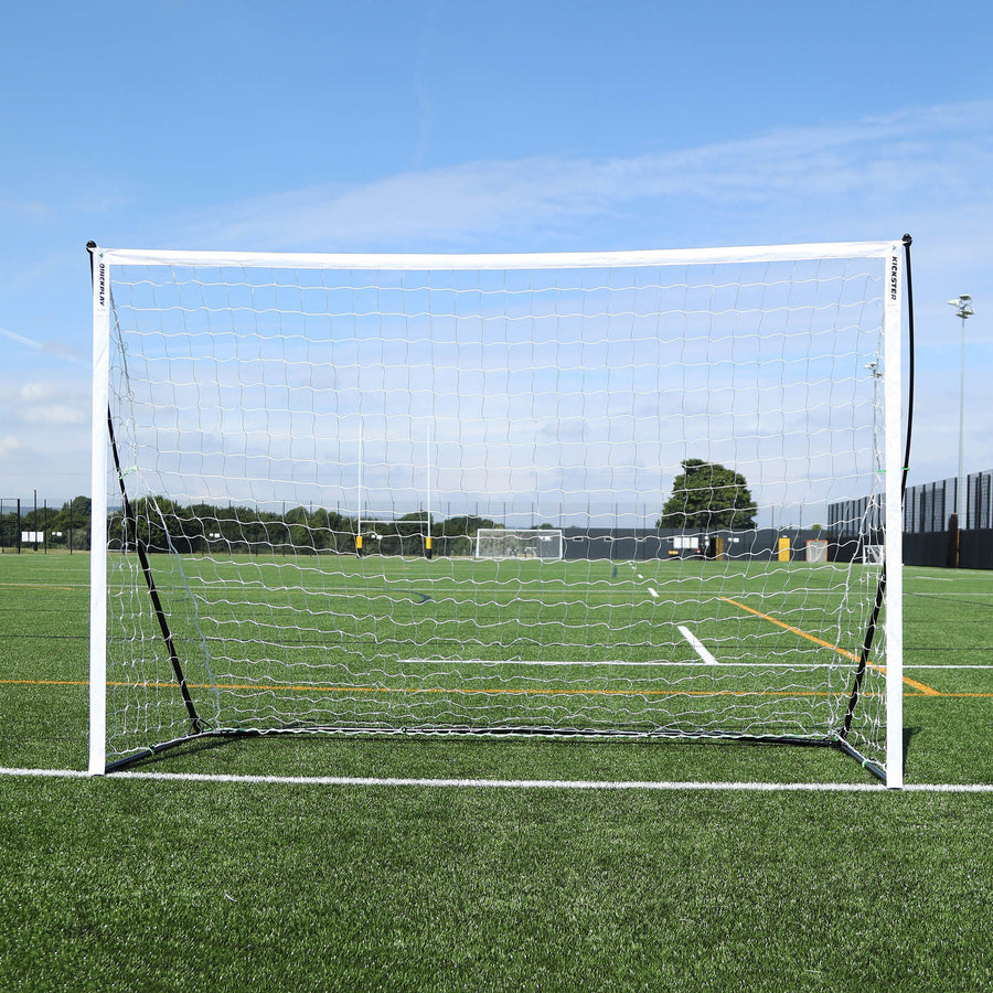 Porta da calcio a 5 KICKSTER Elite 300 x 200 cm vista frontalmente, con telaio e rete bianchi su un campo in erba sintetica.