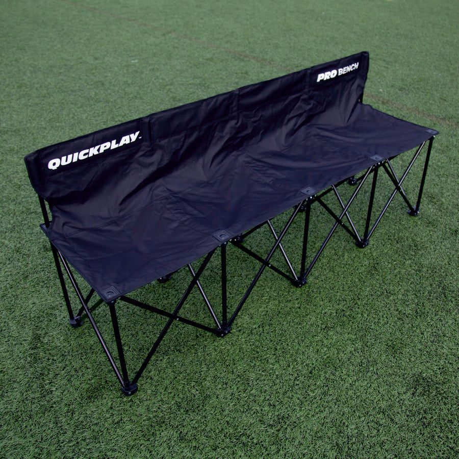 Panchina PRO Bench 4 posti nera vista dall'alto su erba sintetica, con QUICKPLAY e PRO BENCH sullo schienale.