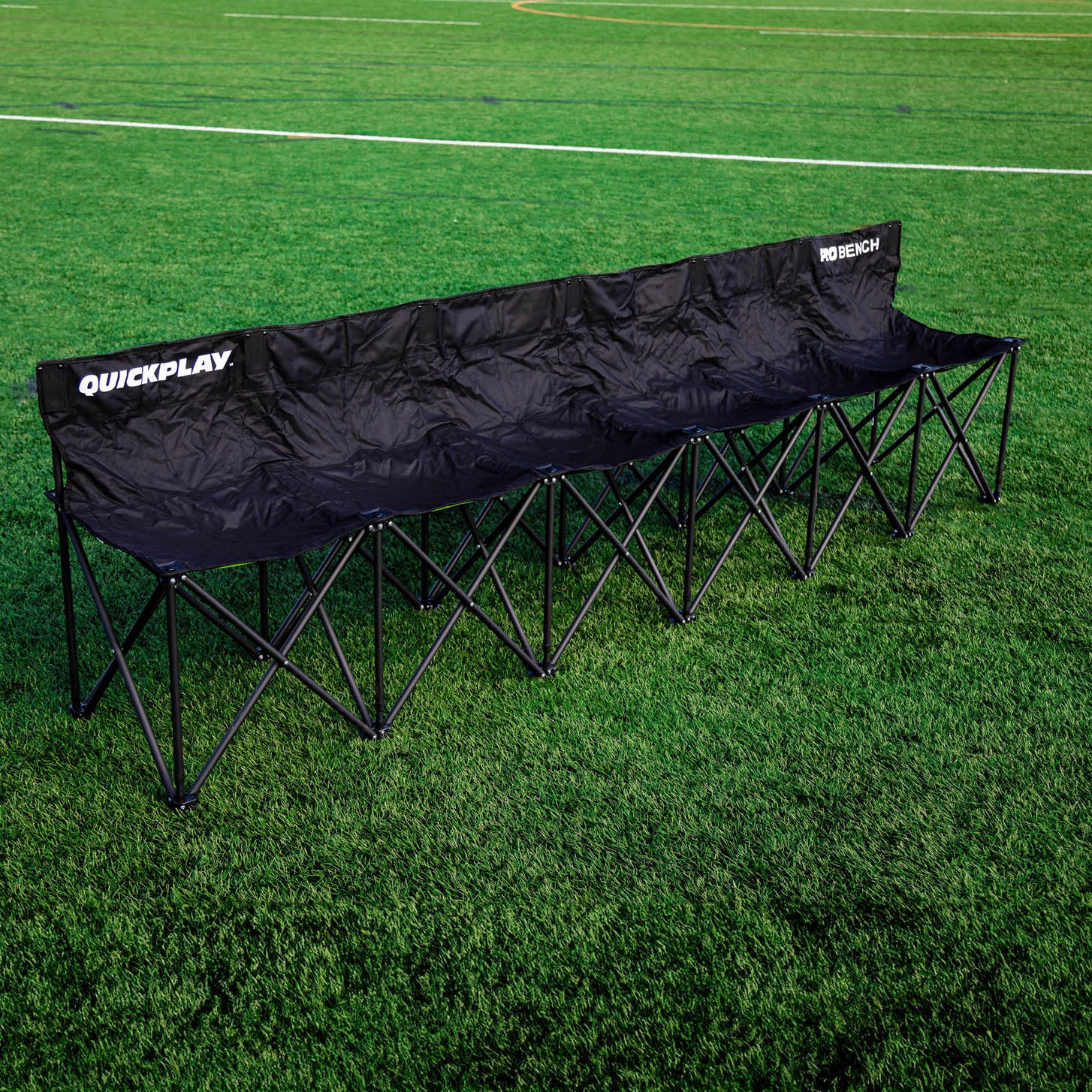 Panchina PRO Bench 6 posti nera aperta su un campo in erba sintetica, vista dall'angolo anteriore.