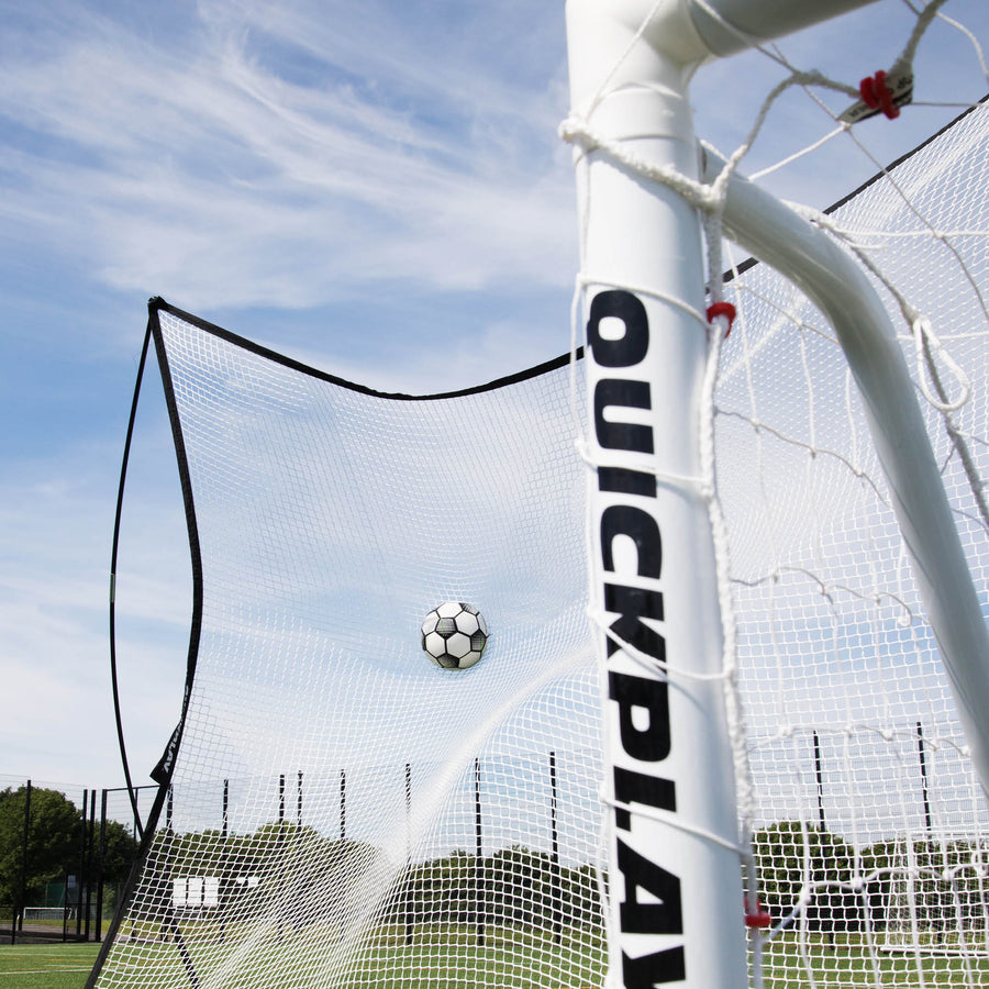 Rete parapalloni MEGA NET 370 x 270 cm che ferma un pallone dietro un palo bianco di una porta QUICKPLAY, ripresa dal basso.