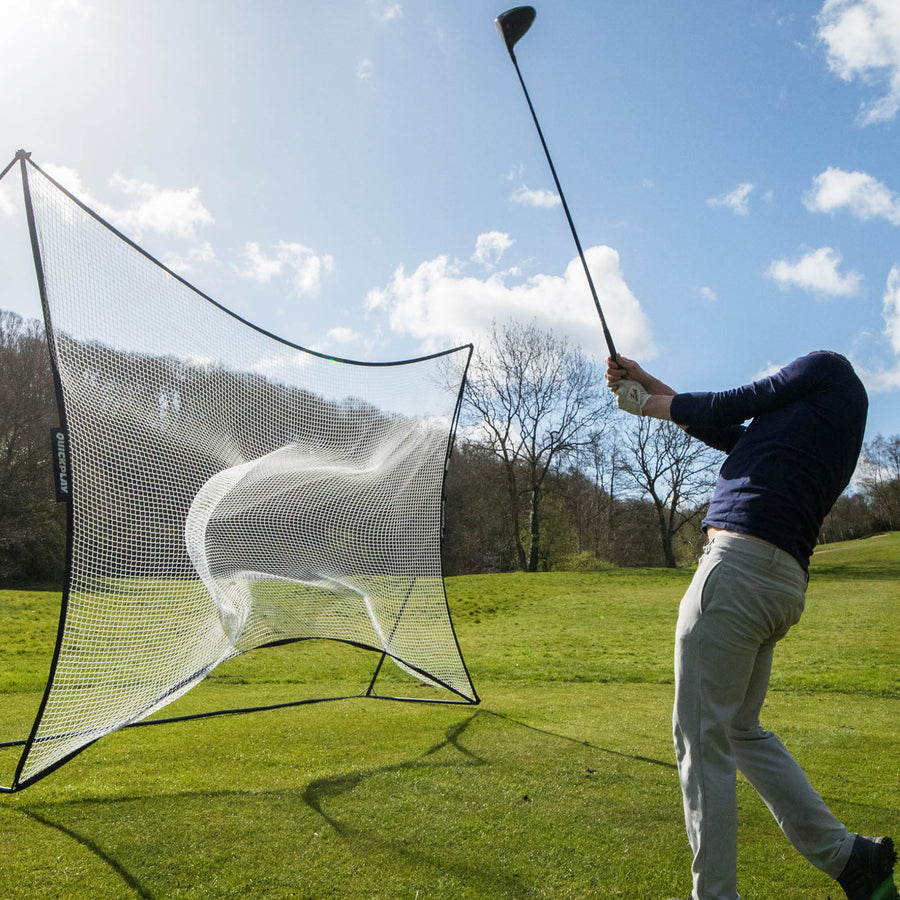 Rete parapalloni MEGA NET 370 x 270 cm su un campo in erba, con un golfista che completa lo swing con un driver dopo aver colpito una pallina nella rete.
