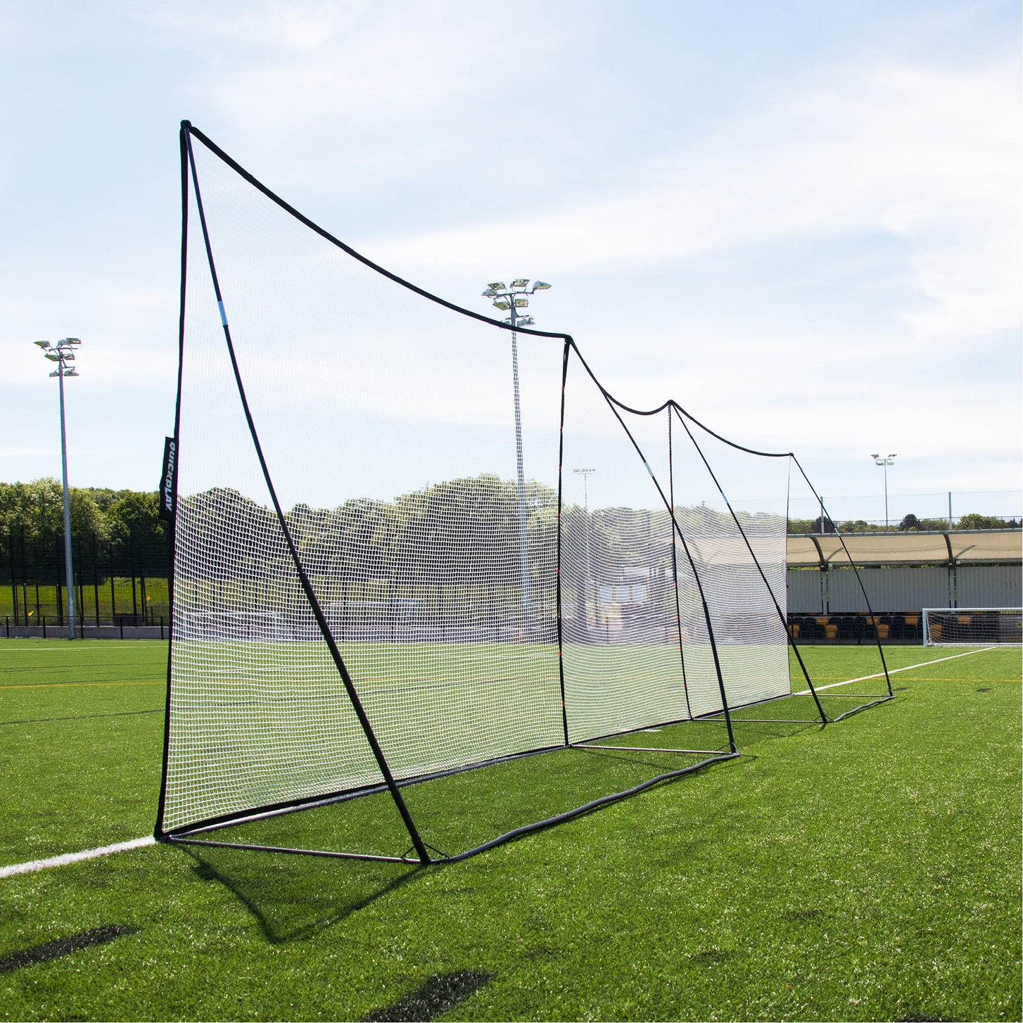 Rete parapalloni MEGA NET 370 x 270 cm montata in una lunga fila con una seconda rete lungo il bordo di un campo in erba sintetica.
