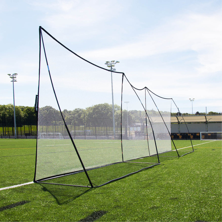 Rete parapalloni MEGA NET 370 x 270 cm montata in una lunga fila con una seconda rete lungo il bordo di un campo in erba sintetica.