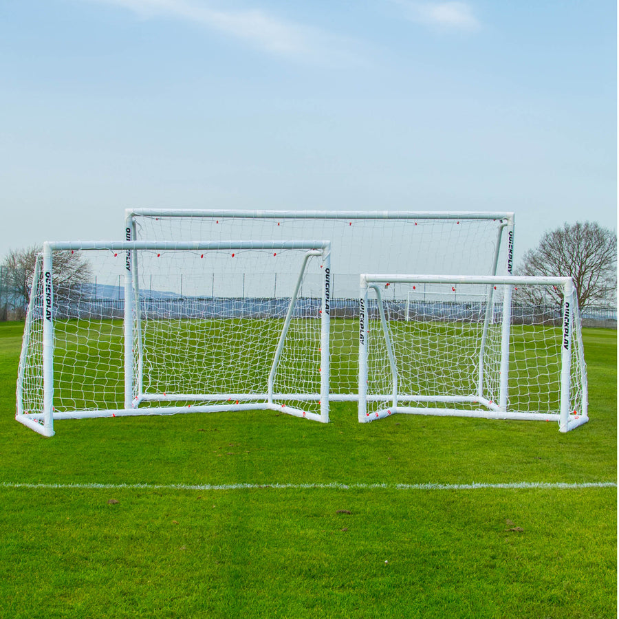 Porta Q-FOLD Match 370 x 180 cm con due porte bianche Q-FOLD Match più piccole, una accanto all'altra su un campo in erba.