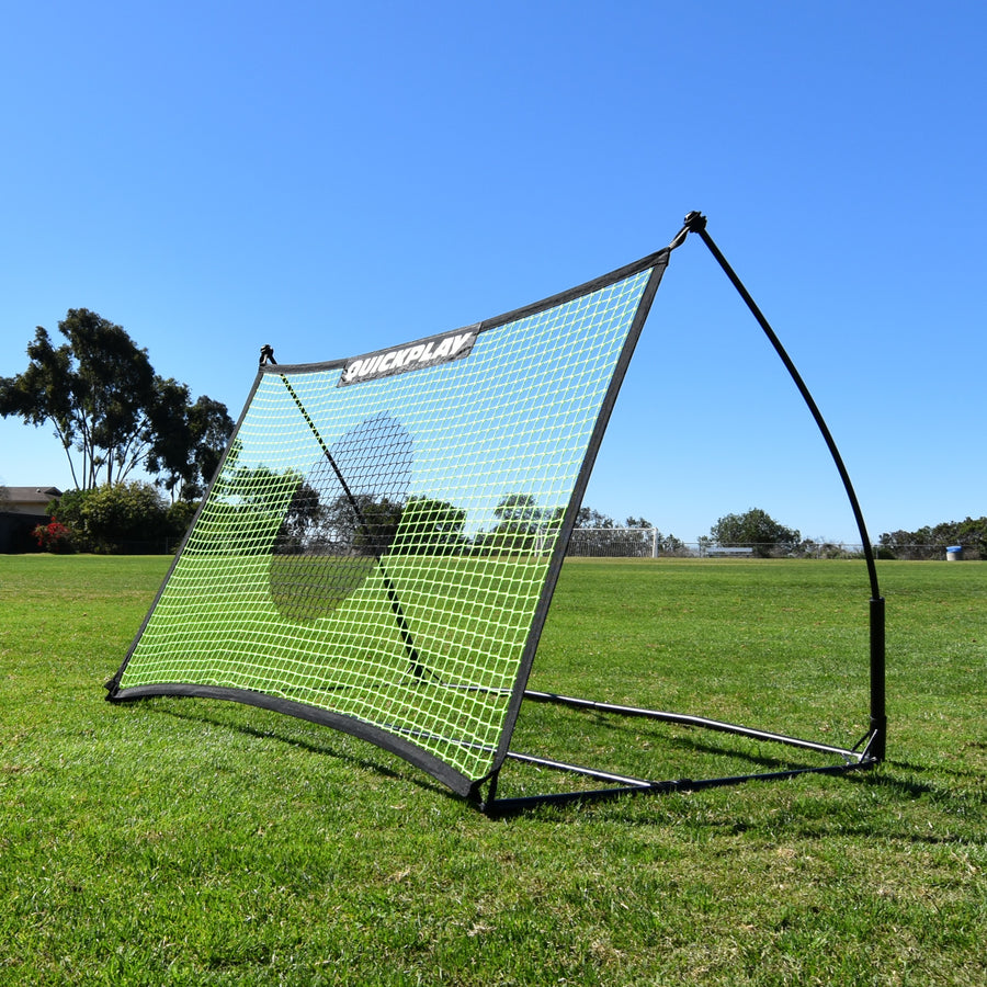 Rebounder da calcio TEKKERS Net 150 x 100 cm sull'erba al sole, visto da un angolo anteriore, con la sua rete verde.